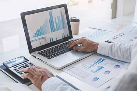 close up of someone working on financial documents on a laptop